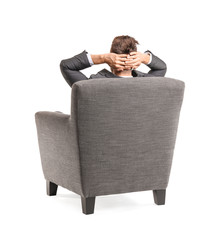 Sticker - Businessman sitting in armchair on white background, back view