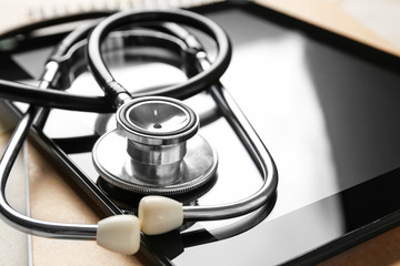 Stethoscope and tablet computer on table, closeup