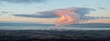 Panorama of the sea bay on which there is a large oil refinery. Smoke rises from its chimneys, which mixes with a huge cloud, sanctified by sunset light. Grangmouth, Scotland