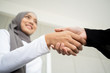 © DG PhotoStock - Beautiful Asian Muslim businesswoman handshake with her colleague close up.