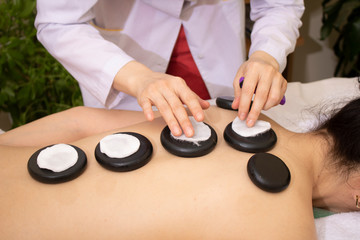 Stone therapy. Massage with warm basalt stones. Focus on the hands