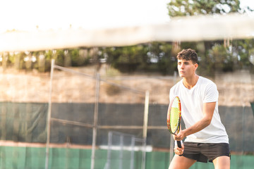 Wall Mural - Young Man Playing Tennis Outdoors.