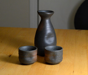 japanese sake serving vase with two cups on wooden table