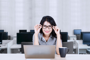 Wall Mural - Asian businesswoman posing by holding her glasses