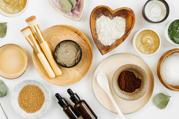 Beauty treatment ingredients for making homemade skin care cosmetic mask. Various bowl with clay, cream, essential oil and natural ingredients  on white table background. Organic spa cosmetic products