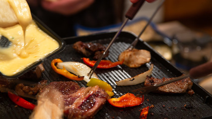 People grilling on an indoors electric grill and sharing food