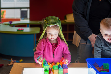 Toddlers playing with colorful blocks at the library