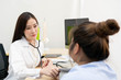 © DG PhotoStock - Beautiful Asian doctor checking blood pressure of unhealthy fat woman.  Health care and wellness concept.