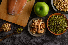 Legumes, Salmon Pieces And Apple On A Black Cement Floor Background.