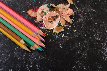 Close-up with color pencils and shavings on Cement floor, flat lay.