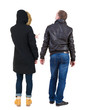 © ghoststone - Back view of couple couple in winter jackets pointing.