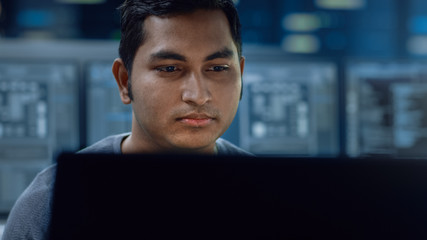 Wall Mural - portrait of a smart and handsome it specialist working on a personal computer. in the background unf