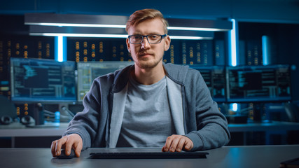 Fototapete - Portrait of Software Developer / Hacker Wearing Glasses Sitting at His Desk and Working on Computer in Digital Identity Cyber Security Data Center. Hacking or Programming.