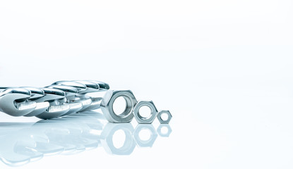 Metal hexagon nuts and chrome wrenches isolated on white background. Mechanic tools for maintenance. Hardware tool. Fastener with a threaded hole. Set chrome spanner wrench and nuts. Silver wrenches.