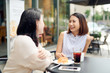 © makistock - people, communication and friendship concept - smiling young women drinking coffee and talking at outdoor cafe