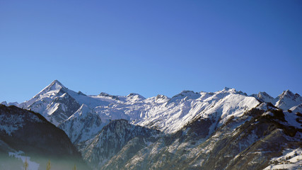 beautiful winter landscape in the alps with fresh snow on a sunny day with clear blue sky