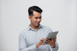 © makistock - Happy young businessman using digital tablet isolated on white background.