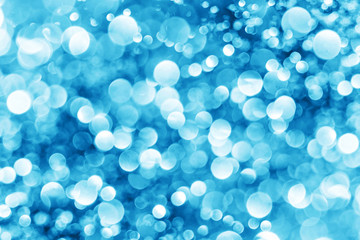 Blue bokeh shiny glitter background. Abstract vibrant color glowing white spots texture for graphic design.
