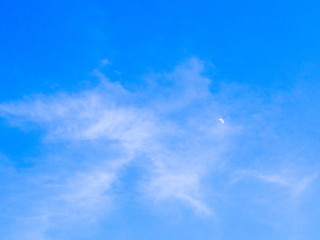 cloudy sky in day time with haft moon, blue sky background