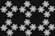 White wooden snowflakes on a black sparkling background. Geometric arnaments. Pattern. The background. Screensaver.