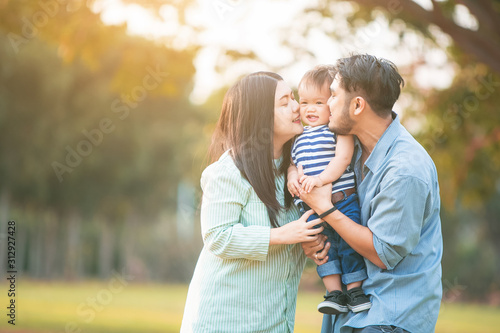 Cuadros en Lienzo Family of happy couple with baby in park outdoors.