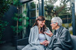 © bnenin - Family gathering concept. Two women of different age talking on the patio of modern house.