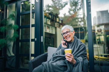 Positive senior short haired woman talking on mobile phone, portrait.