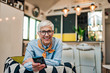 © bnenin - Stylish elderly woman at home, holding smart phone and smiling at camera.