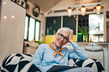 Poster - Enjoying retirement. Portrait of a gorgeous senior woman relaxing at home, looking at camera.