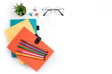 Wall Mural - Flat lay black to school and education concept on white table desk with stack of book and pencil, green plant and supplies, Top view with copy space, work space