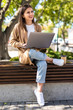 © F8  \ Suport Ukraine - Young beautiful business woman working on a laptop sitting on the bench in the street