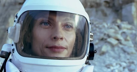 close up of the caucasian beautiful face of young woman astronaut in the head armor smiling. portrai
