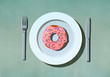 © fStop - Pink donut with sprinkles on plate