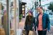 © camrocker - Caucasian couple wearing warm clothing window shopping from outdoors in the winter time.