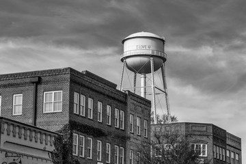 Water tower over brick buildings in monochrome