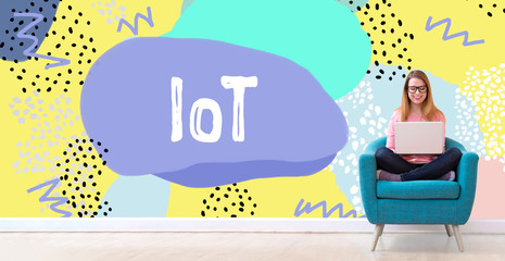 IoT with young woman using her laptop in a chair