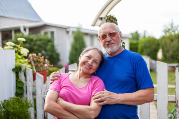 Poster -  Mature couple at wicket gate of   village cottage