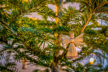 angel made of straw, hanging in a christmas tree