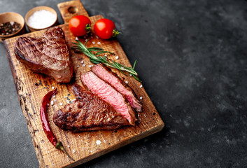 Wall Mural - two grilled beef steaks in the form of a heart with spices for Valentine's day on a stone background with copy space for your text. dinner concept for two for Valentine's Day celebration