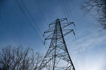 A high voltage electricity transmission pylon in winter - part of the national grid for the distribution of power by overhead cables in the UK.