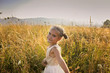 © Maria - Cute girl dancing through a beautiful meadow with wheat and flowers in the mountains