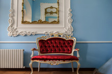 Close Up Photo Of A Red Sofa In Royal Style In A Room With Blue Walls And A Mirror