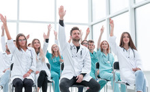 Medical Students Raising Their Hands During The Seminar.