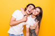 © F8  \ Suport Ukraine - Young couple posing together while making selfie and woman showing thumb up, over yellow background