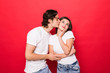 © F8  \ Suport Ukraine - Portrait of beautiful smiling couple kissing over red background.