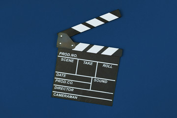 Film clapper board on classic blue background top view