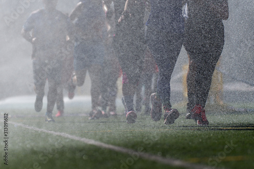 Fotografía A group of runners during a marathon while it is raining, the group runs to the