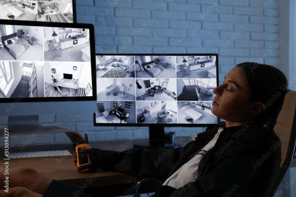 Female security guard sleeping near monitors at workplace - obrazy, fototapety, plakaty 