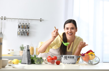 Sticker - Young woman tasting delicious soup in kitchen