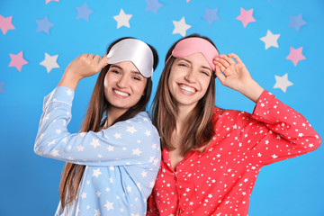 Poster - Beautiful women wearing sleeping masks on light blue background. Bedtime